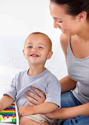 Buy stock photo Mom playing with happy toddler in home with toys, bonding and child care with abacus in morning on bed. Woman, playful baby boy and fun together in bedroom with development, smile and mothers love.