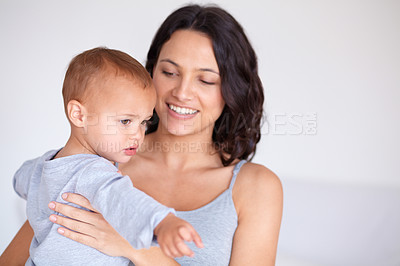 Buy stock photo Mom holding toddler in home with smile, bonding and child care with support in morning. Happy woman, baby boy and spending time together in bedroom with development, trust and safety in mothers love.