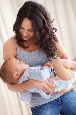 Buy stock photo Mom holding toddler in home with playful smile, bonding and child care with support in morning. Happy woman, baby boy and spending time together in bedroom with development, trust and mothers love.