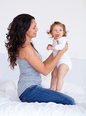 Buy stock photo Bonding, sweet and mother playing with baby on bed in morning together at family home. Happy, smile and young mom having fun with girl infant, kid or toddler for child development in bedroom at house