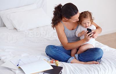 Buy stock photo Phone, playing and mother with baby on bed for bonding and watching video on social media together. Happy, love and young mom scroll on cellphone with girl child, kid or toddler in bedroom at home.
