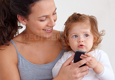 Buy stock photo Phone, playing and mother with toddler on bed for bonding and watching video on social media together. Happy, love and young mom scroll on cellphone with girl child, kid or baby in bedroom at home.
