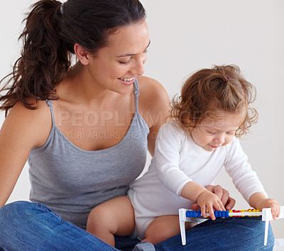 Buy stock photo Mom playing with happy baby in home with toys, bonding and child care with support in morning on bed. Woman, playful toddler girl and fun together in bedroom with development, smile and abacus.