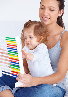 Buy stock photo Abacus, math and girl baby with mom playing, learning and teaching for child development on bed. Bonding, toy and young mother teaching kid, infant or toddler with counting in bedroom at home.