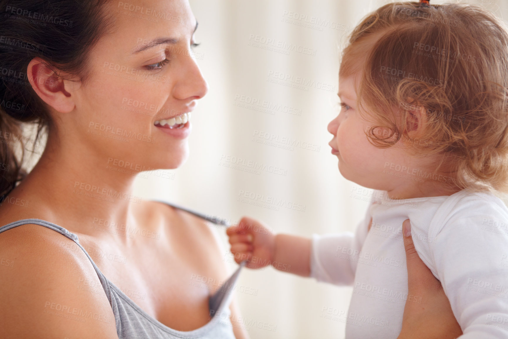Buy stock photo Mom holding baby girl in home with smile, bonding and child care with support in morning. Happy woman, toddler and playing together in bedroom with development, trust and safety with mothers love.