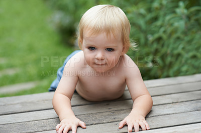Buy stock photo Baby, relax and floor outdoor for development with playing, curiosity or early childhood in backyard of home. Toddler, child and crawling on ground for wellness, milestone or exploring with innocence