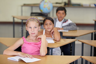 Buy stock photo Portrait, serious kids and student in classroom with book, ready to learn and study in class. Group of students, education and girl learning in primary school for knowledge, development or studying.