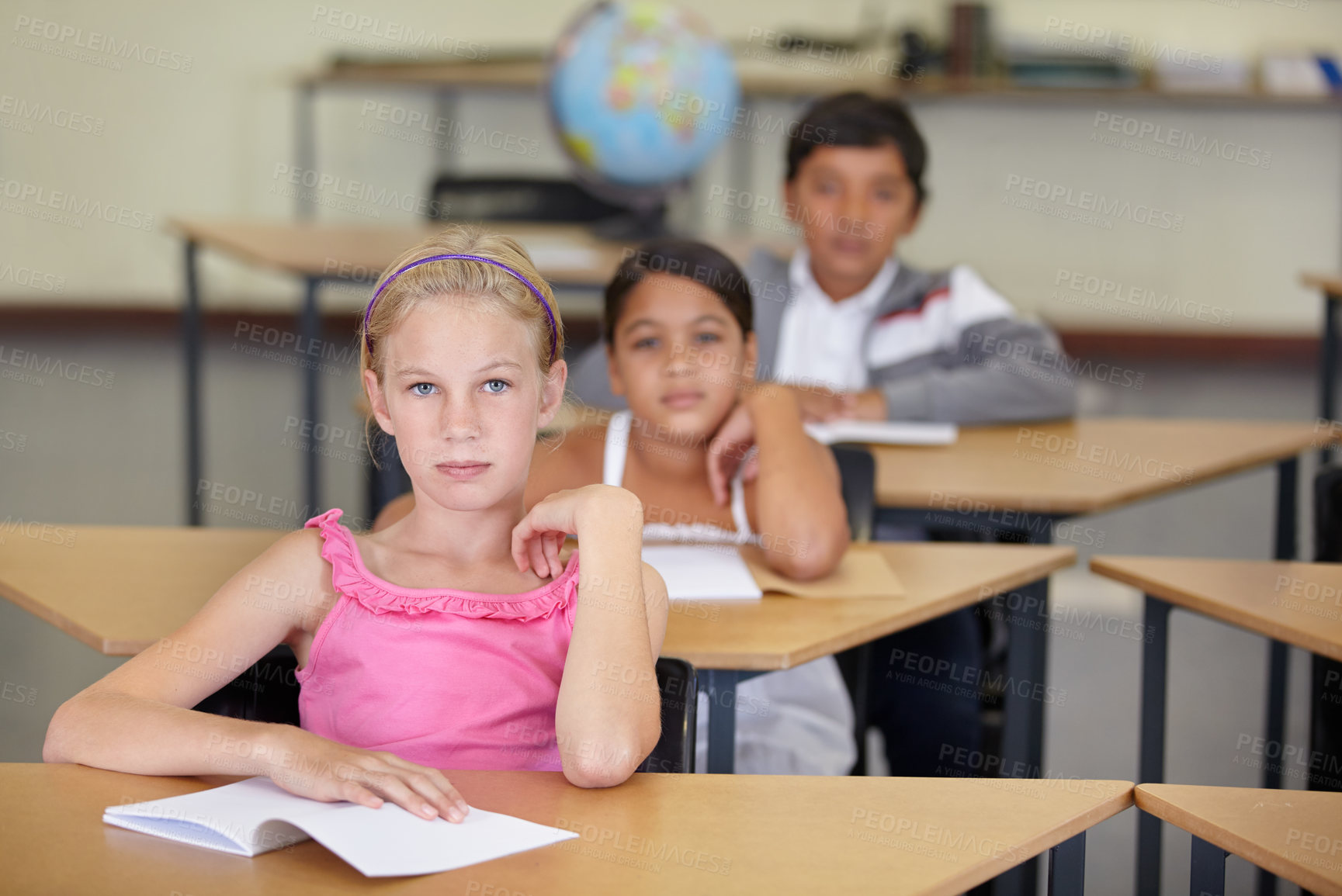 Buy stock photo Portrait, serious kids and student in classroom with book, ready to learn and study in class. Group of students, education and girl learning in primary school for knowledge, development or studying.