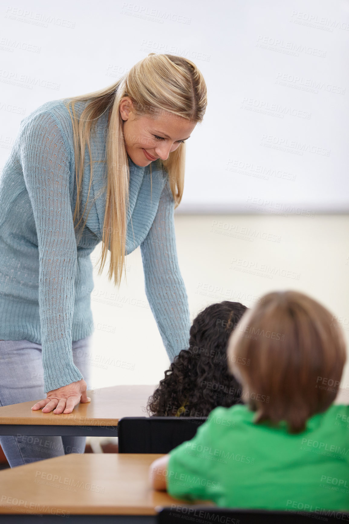 Buy stock photo Teacher, children and students in classroom for education, learning and language development or support at desk. Happy woman with kids for teaching, helping with knowledge and questions at school