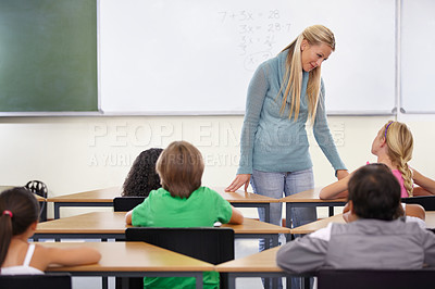 Buy stock photo Teacher, kids and students in classroom for learning, education and math support or development at desk. Happy woman with children for teaching numbers, helping with knowledge and questions at school