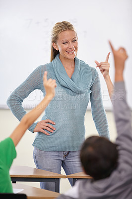 Buy stock photo Question, woman and teacher with students, children and knowledge in a classroom. School, employee and kids with hands in the air, answer and child development with educator, learning and happiness