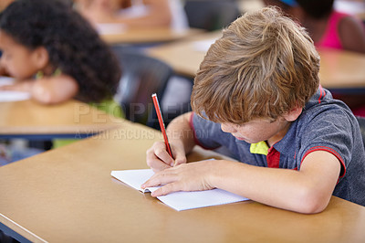Buy stock photo School, boy and kid writing in notebook in classroom, desk and studying for education, knowledge and academic assessment. Child, student and drawing in book for learning lesson, test and development