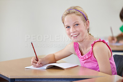 Buy stock photo Portrait, child and smile of student learning in classroom for knowledge, education or development. Happy, girl and learner writing in notebook, studying or taking notes in middle school in Canada.