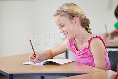 Buy stock photo School, girl and smile for writing in classroom, studying lesson or learning assessment at desk. Child, student or happy kid drawing in notebook of academic development, educational test or knowledge