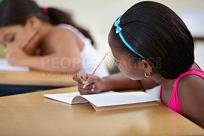 Buy stock photo School, child and writing in book in classroom, desk and studying for education, knowledge or learning assessment. African girl, kid and student with notebook for academic development, test or lesson