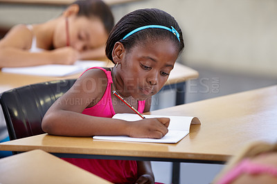 Buy stock photo A young girl in a classroom concentrating on her test