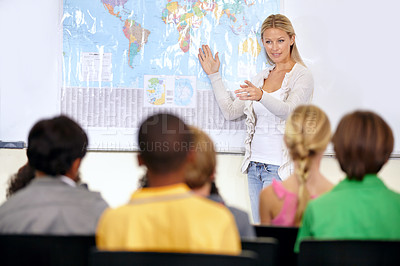 Buy stock photo Teacher, geography and map in classroom with kids, pointing and smile with test question. Person, teaching and talking to school children for education, learning or development with quiz at academy