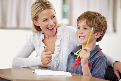 Buy stock photo Thumbs up, happy teacher with student in classroom in school and teaching. Correct or success, education or learning and female educator helping male child with homework or question at desk.