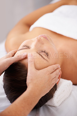 Buy stock photo A young woman lying in a beauty spa receiving a relaxing head massage