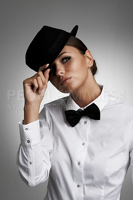 Buy stock photo Fashion, beauty and woman tipping her hat in studio isolated on a grey background. Classy, clothes or young model in fedora, style of serious person and face expression of girl thinking on a backdrop