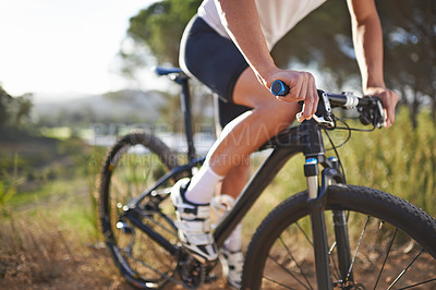 Buy stock photo Cropped view of a man mountain biking in nature