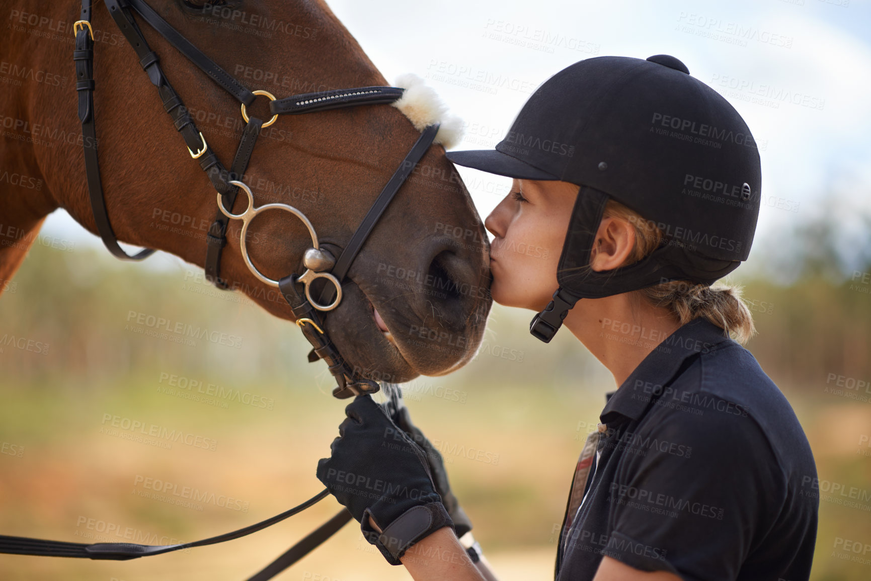 Buy stock photo A young female rider being affectionate with her chestnut horse