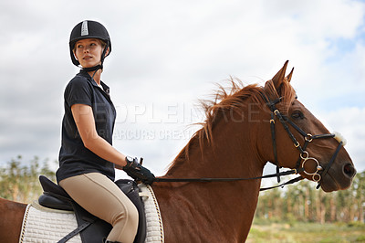 Buy stock photo Equestrian, riding and woman on horse in nature on adventure and journey in countryside. Ranch, animal and rider outdoor with hobby, sport or pet on farm trail with girl in summer on blue sky