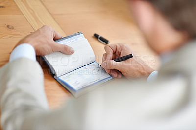 Buy stock photo Cropped closeup shot of a businessman signing cheques