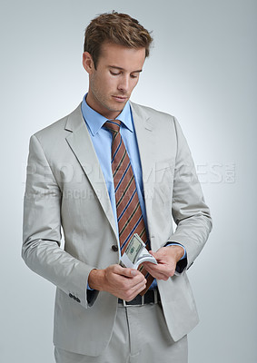Buy stock photo Businessman, face and dollar or finance in studio for money laundering, white collar crime or investment. Cash, entrepreneur and person with stealing and fraud at corporate job on gray background
