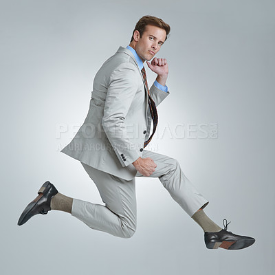 Buy stock photo Businessman, achievement and jumping for success in portrait, studio and fist pump for triumph. Male person, mockup space and victory to celebrate, confident and energy for win by gray background