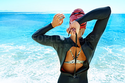Buy stock photo Rearview shot of a female open water swimmer preparing to enter the ocean
