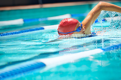 Buy stock photo Shot of a professional female swimmer freestyle swimming in her lane