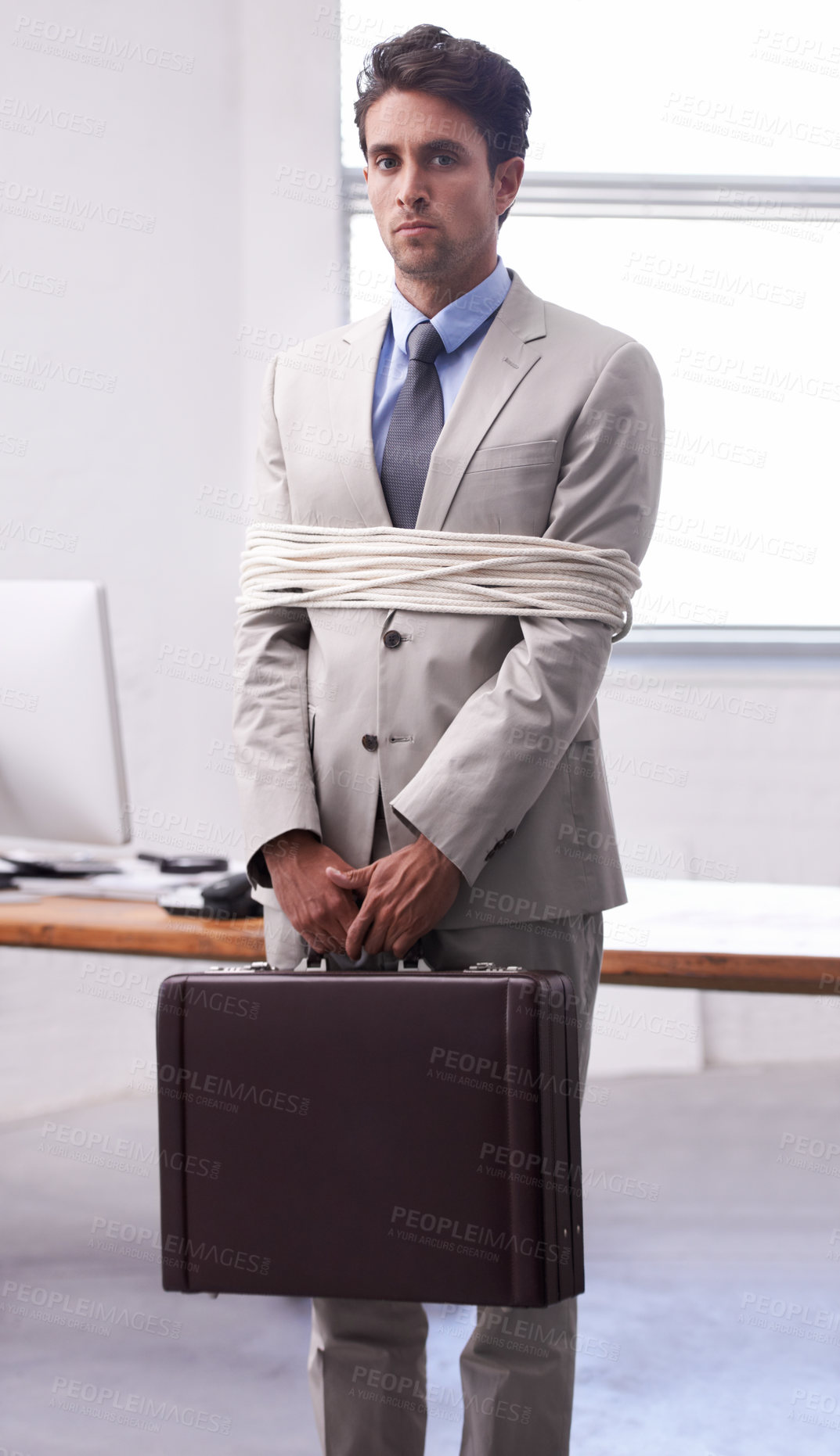 Buy stock photo Portrait of businessman in office tied up in rope with depression, control and fear in law firm. Serious attorney, lawyer or legal consultant bound at work, corporate hostage with bag and stress.