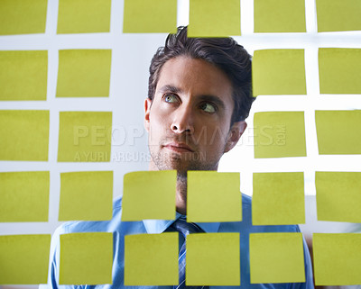 Buy stock photo Businessman, face and thinking with sticky note for brainstorming, planning agenda and ideas on glass at office. Focus man contemplating business decision, strategy and problem solving for solution