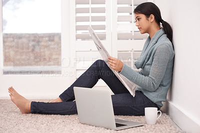 Buy stock photo Newspaper, reading news and woman in a home with article, paper and press media for research. Morning, writer and remote work of an Indian female person with coffee and laptop for writing in a house