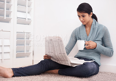 Buy stock photo Woman, reading and newspaper with coffee in a home at morning with story, article and news. Relax, press print and calm female person from India with paper publication and media in a house on floor