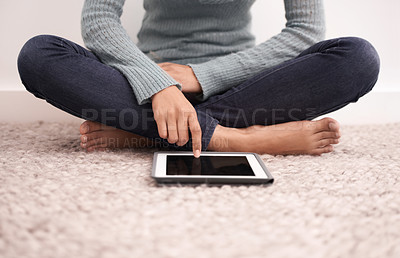 Buy stock photo A woman using a digital tablet on her bedroom floor