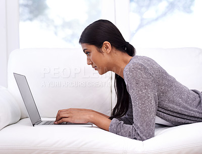 Buy stock photo Woman, laptop and relax on sofa for online education, e learning or research for home school or streaming website. Young person or student typing on a computer or notebook in living room or lounge