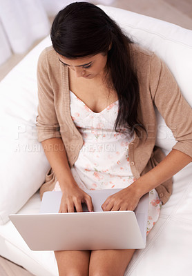 Buy stock photo Woman on sofa with laptop, typing and relax with remote work, website and browse in living room from above. Girl on couch with computer for freelance job, online web research and internet in home.