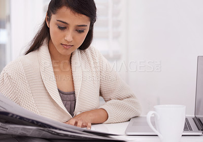 Buy stock photo Woman, morning newspaper and reading in home by laptop for remote work, economy or check stock market. Person, trader and newsletter for financial stats, information or thinking by computer in house
