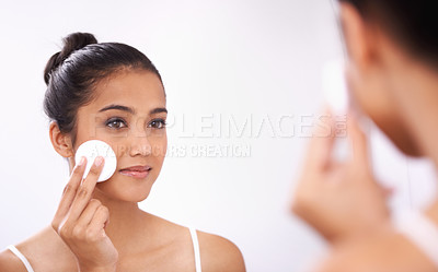 Buy stock photo Woman, cotton pad and face in mirror for makeup, skincare or cosmetics in bathroom at home. Attractive young female person or model smile for grooming skin, facial treatment or removal in reflection