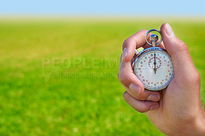 Buy stock photo Cropped shot of a hand holding a stopwatch against a field