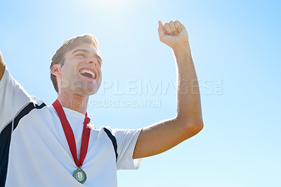 Buy stock photo Winner, man or athlete with sports medal for achievement, success and celebration in running competition. Happy or excited runner with fist, power and wow for gold award. prize or goals on a blue sky