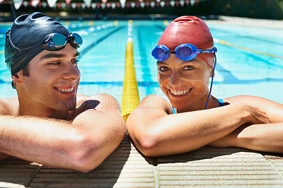 Buy stock photo Two happy young swimmers standing in the pool smiling at the camera