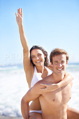 Buy stock photo Portrait, energy and piggyback with couple on beach together for holiday, vacation or romantic getaway. Smile, travel or love with happy young man and woman by ocean or sea for coastal adventure