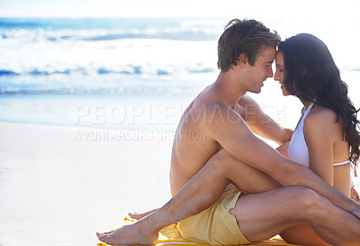 Buy stock photo A blissfully happy couple looking into one another's eyes while on the beach