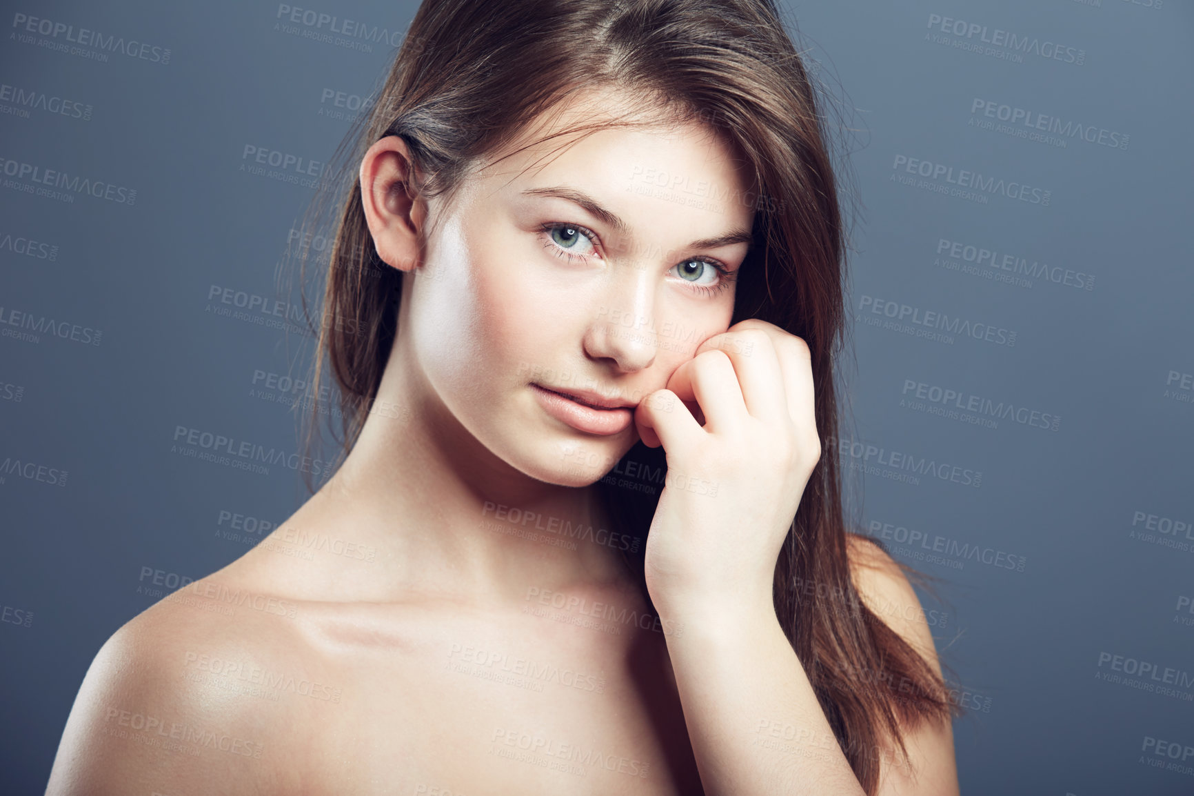 Buy stock photo Natural, face and portrait of a shy woman in studio with a glow, beauty and cosmetics. Headshot of a young female model on a grey background for shine, hair care and facial skincare or dermatology