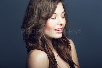 Buy stock photo Beauty, cosmetic and young woman in a studio with a natural, face and makeup routine. Self care, beautiful and young female model with cosmetics, dermatology or skincare treatment by blue background.