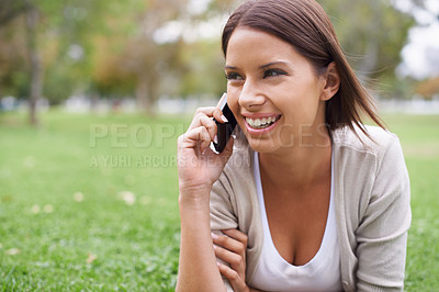Buy stock photo Woman, phone call and communication on grass for connection, conversation or advice. Female person, digital device and smile in nature or speaking chat for exciting news, information or discussion