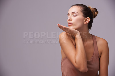 Buy stock photo Skincare, blow kiss and young woman in studio with health, wellness and dermatology routine. Cosmetic, confident and female person with natural facial treatment and flirt gesture by gray background.
